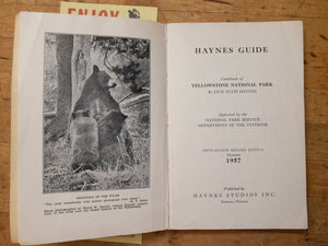 vintage haynes guide to yellowstone open featuring black and white photo of mother bear and cubs in the forest
