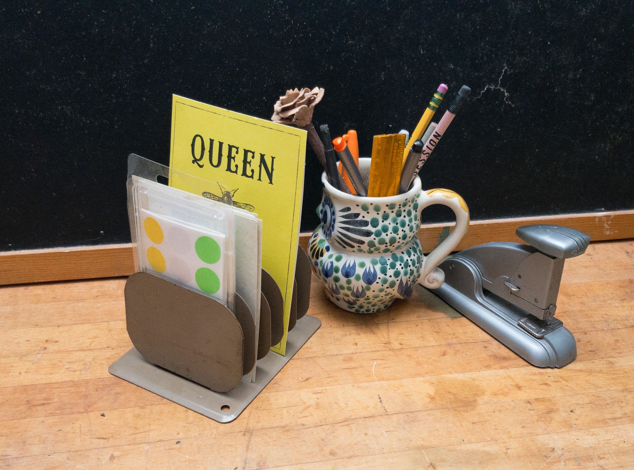 Metal paper organizer with papers and office supplies on a week desk